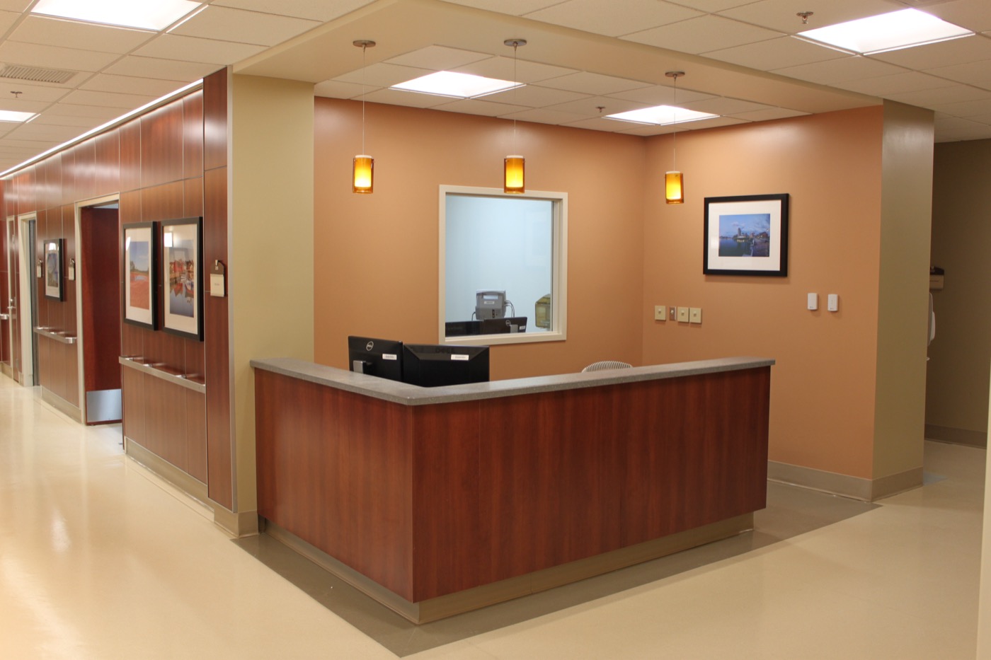 Hospital corridor with wood-paneled reception desk
