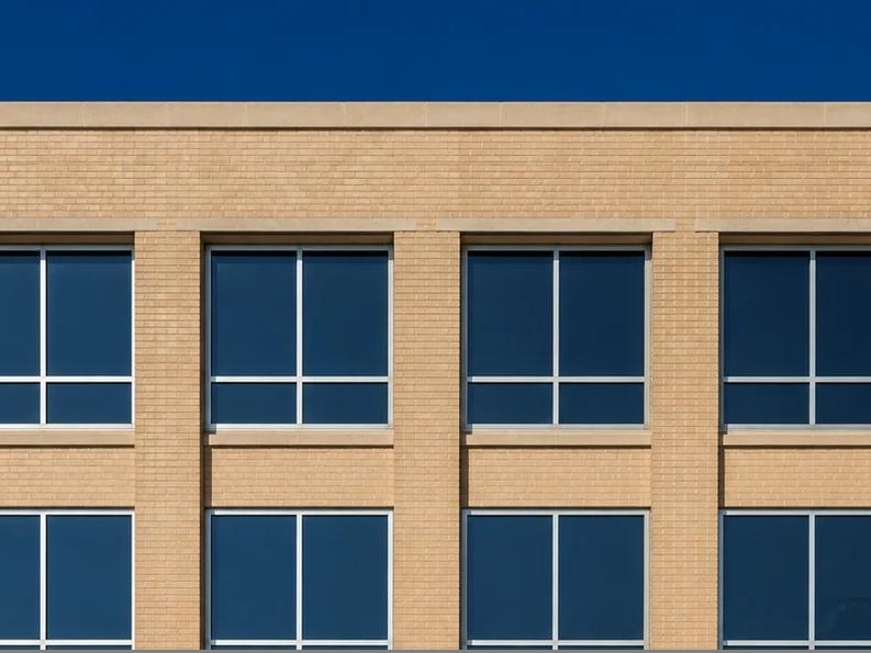 Illustrative photo of a masonry hospital building facade with replacement windows