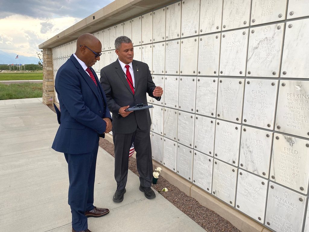 Two visitors walking along a columbarium niche wall