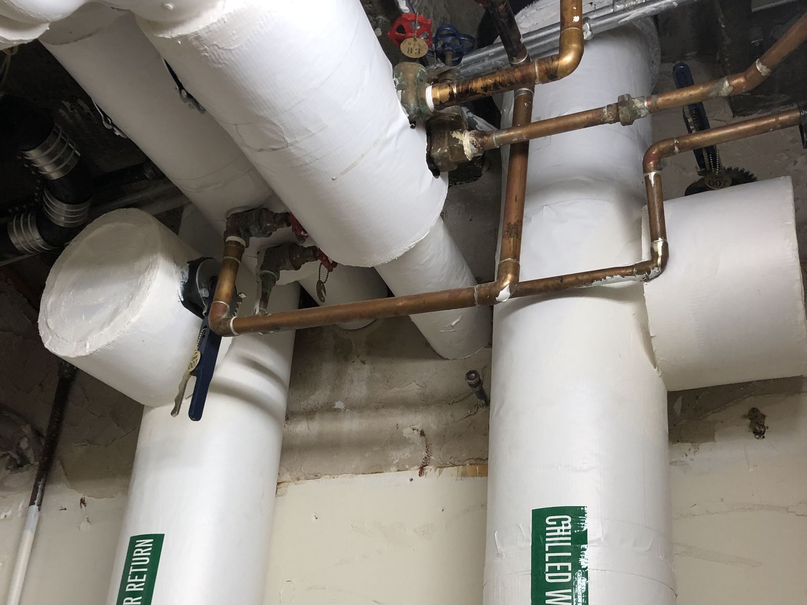 Insulated chilled water supply and return piping in a mechanical space at the Manchester VA Medical Center